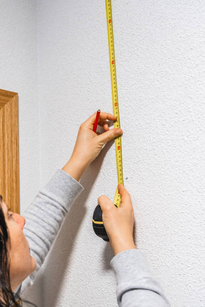 istock A woman taking measurements on a white wall 1202226653