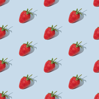 Colorful seamless pattern made of red strawberries on blue background