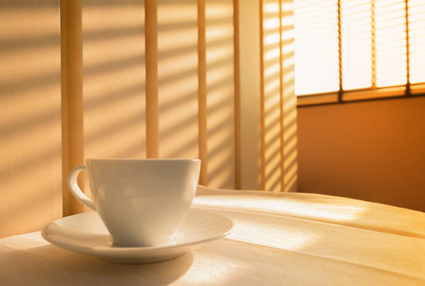 istock classic white coffee cup set with interior design, beautiful pattern of shadow on empty vintage wooden wall texture by sunlight through the window blind curtain of business office for urban lifestyle 1202228052