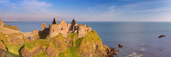 Early morning sunlight over Dunluce Castle at the Causeway Coast of Northern Ireland.