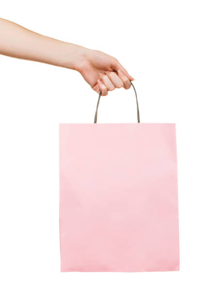 istock Hand with pink paper bag on white 1202231778