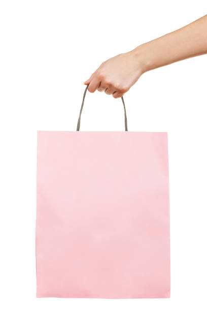 istock Hand with pink paper bag on white 1202231788
