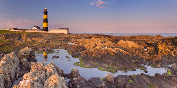 istock Lighthouse in Northern Ireland at sunset 1202232279