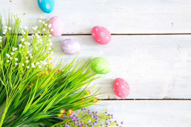 istock Easter eggs and flowers on a white wooden planks 1202232992