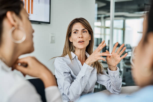istock Businesswoman explaining colleagues in office 1202233001