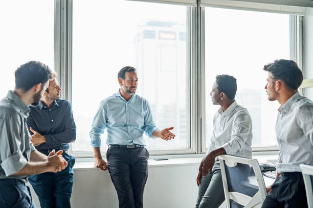 istock Businessman explaining coworkers in office 1202233120