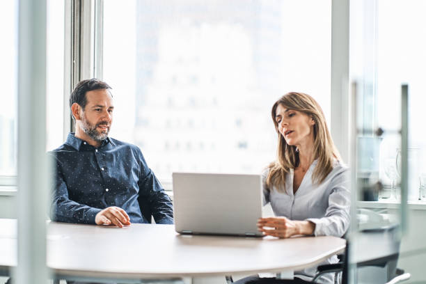 istock Colleagues discussing over laptop in office 1202233398