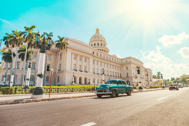 auto retrò americana d'epoca cavalca su una strada asfaltata di fronte al campidoglio nella vecchia avana. taxi turistico cabriolet. - havana foto e immagini stock