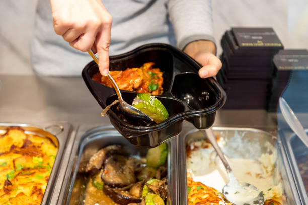 istock Pouring ready meals into compartments of plastic container 1202233529