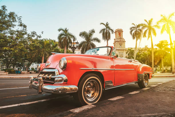 coche americano clásico sobre el fondo de las palmeras al sol brillante por la noche en la habana sobre el fondo de la arquitectura colonial - havana fotografías e imágenes de stock
