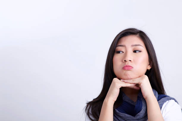 istock asian chinese woman hands on chin doubt 1202233778