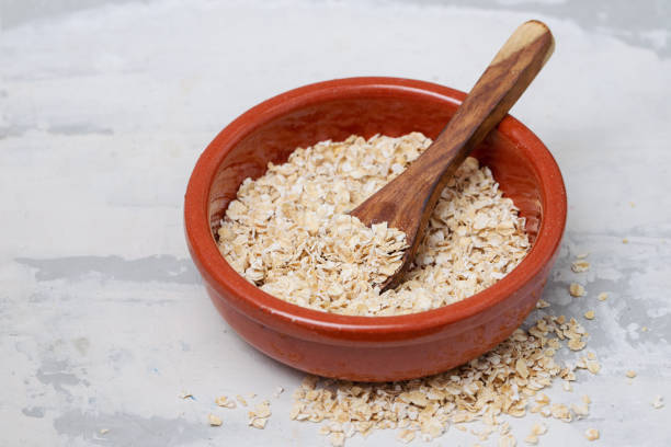 istock dry oats with spoon in ceramic bowl 1202234929