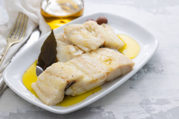 istock boiled cod fish with bay leaf and olive oil on white dish on ceramic background 1202234957