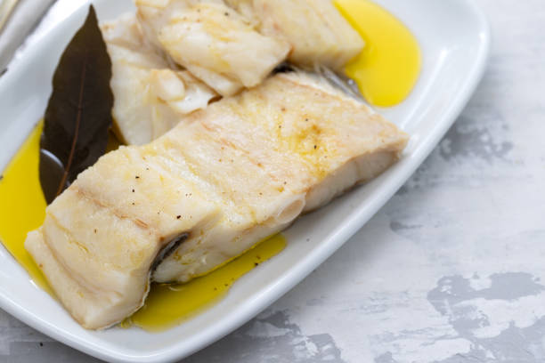 istock boiled cod fish with bay leaf and olive oil on white dish on ceramic background 1202234960