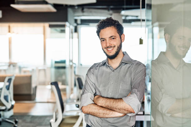 istock Confident businessman with arms crossed in office 1202236391