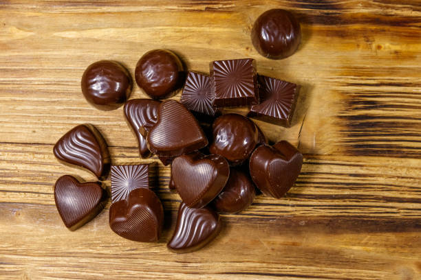istock Tasty chocolate candies on wooden table. Top view 1202236769