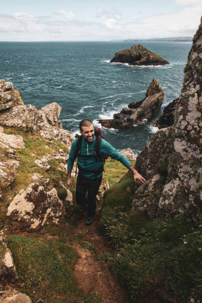 istock Solo traveler exploring the rocky coastline in Cornwall, UK 1202236770