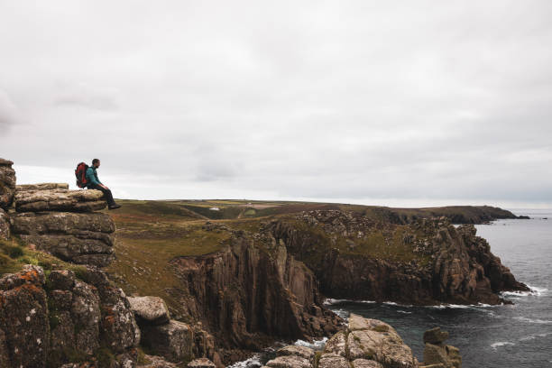 istock Solo traveler exploring the rocky coastline in Cornwall, UK 1202236851