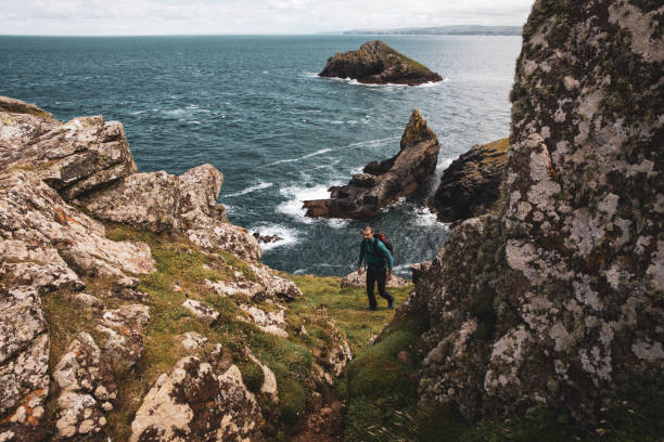 istock Solo traveler exploring the rocky coastline in Cornwall, UK 1202236852