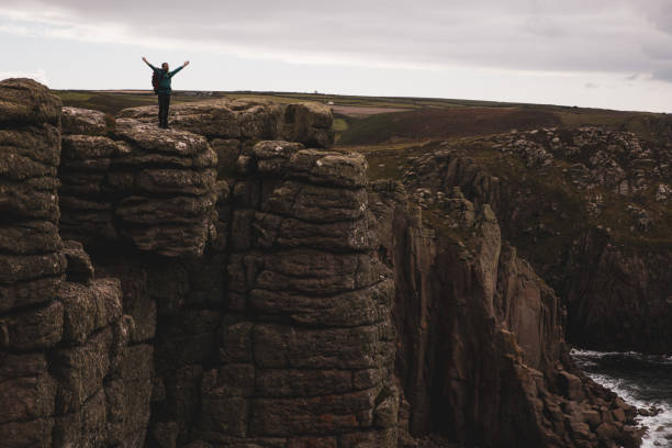 istock Solo traveler exploring the rocky coastline in Cornwall, UK 1202236892