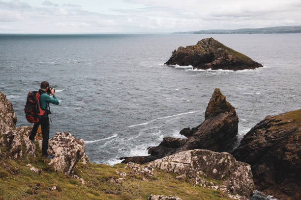 istock Solo traveler exploring the rocky coastline in Cornwall, UK 1202236902
