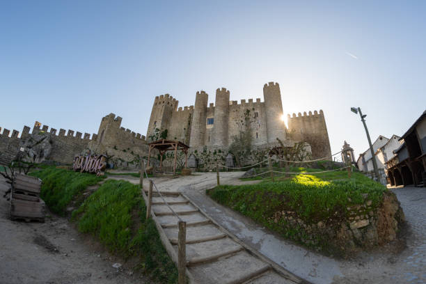 Morning view of the Obidos Castle, wide angle fisheye lens photo with sunflare Obidos, Portugal - January 19, 2020: Morning view of the Obidos Castle, wide angle fisheye lens photo with sunflare obidos photos stock pictures, royalty-free photos & images