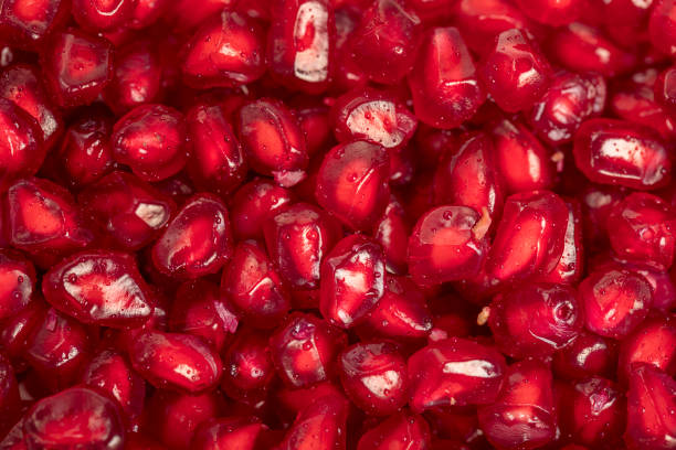 Ripe red pomegranate seeds close up, to view , seamless background stock photo