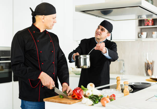 istock Male chefs  in black uniform having quarrel at workplace on kitchen 1202240415