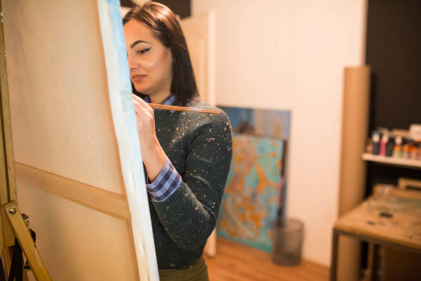 istock Female artist painting on canvas 1202241161