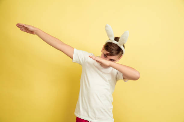 istock Easter bunny boy with bright emotions on yellow studio background 1202241363