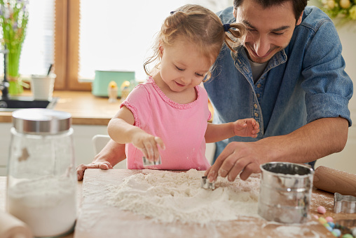 Daughters helping father with baking