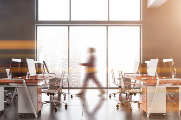 istock Blurry businessman walking in gray office 1202247183