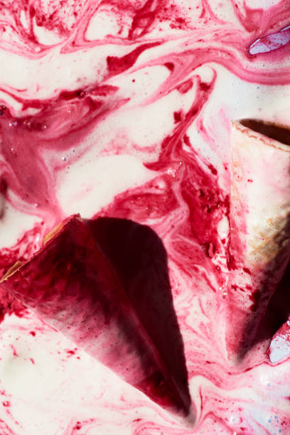 istock Close-up view of waffle cones lying in melted raspberry ice-cream with pink patterns 1202247330
