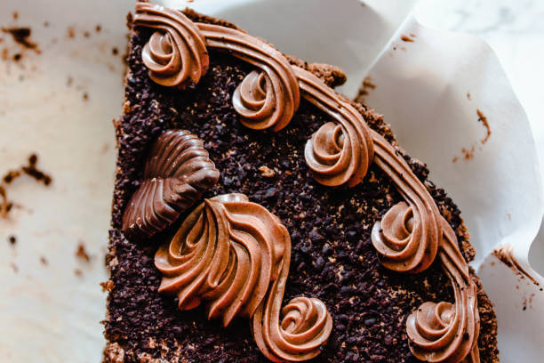 istock Chocolate birthday cake cut into several pieces with decoration.Top view.Close-up 1202247971
