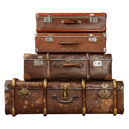 Pile of vintage suitcases isolated on white background. Vintage travel luggage