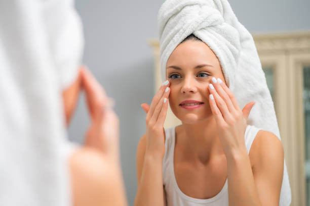 istock Happy woman looking at her skin 1202249088