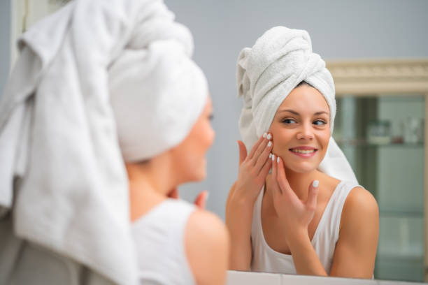 istock Happy woman looking at her skin 1202249106