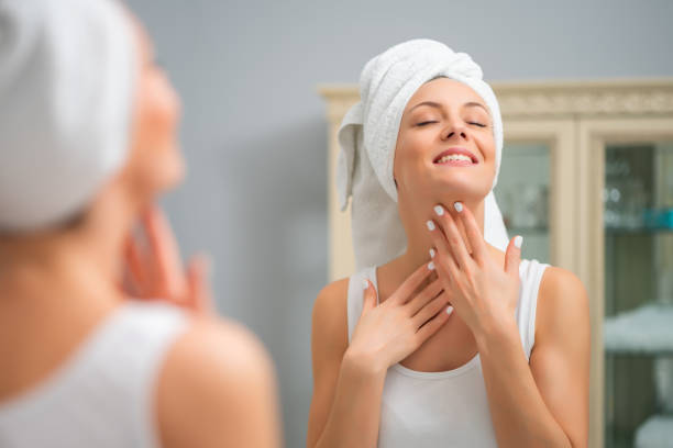 istock Happy woman looking at her skin 1202249133