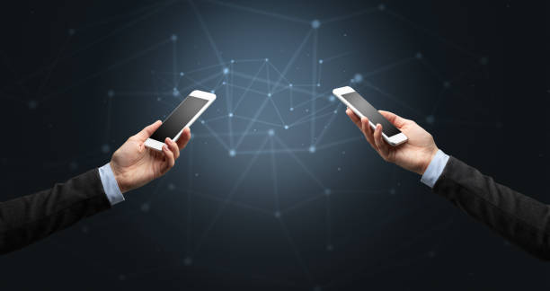 istock Close up of two hands holding smartphones 1202249332
