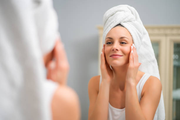 istock Happy woman looking at her skin 1202249624