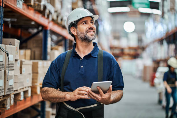 ältere mitarbeiter, die digitales tablet im lager verwenden - warehouse worker stock-fotos und bilder