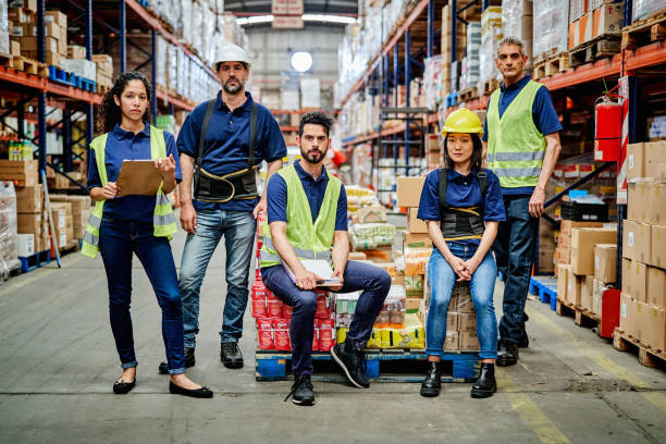 istock Portrait of confident workers with boxes at warehouse 1202250872