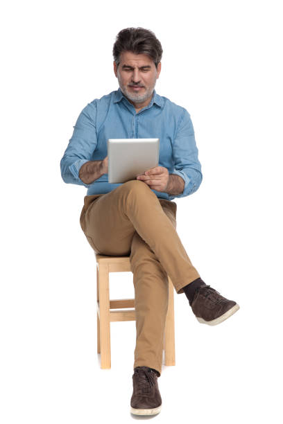 istock Happy casual man reading and writing on his tablet 1202251271