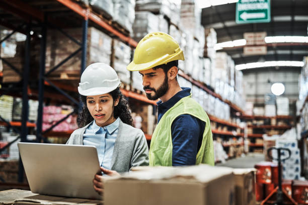 istock Colleagues discussing over laptop at warehouse 1202251307