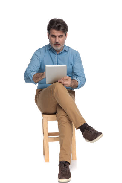 istock Relaxed casual man reading and writing on his tablet 1202251433