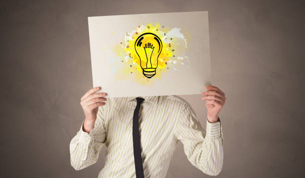 istock Person holding a paper with colorful bulb concept 1202251799