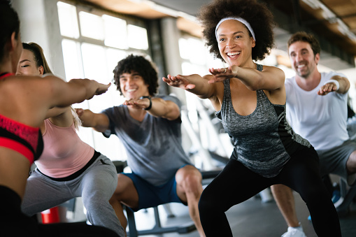 Group of happy fit people at the gym exercising