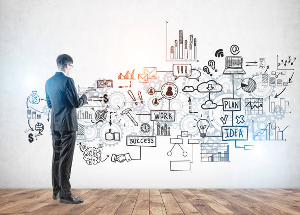 istock Businessman with glasses looking at business plan 1202254282