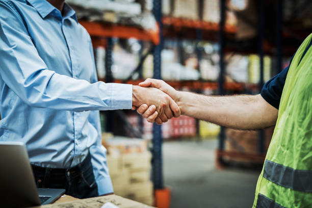 istock Mature employees shaking hands at warehouse 1202255380