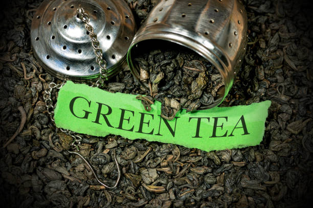 Green Gunpowder Tea with steel strainer and piece of paper with text